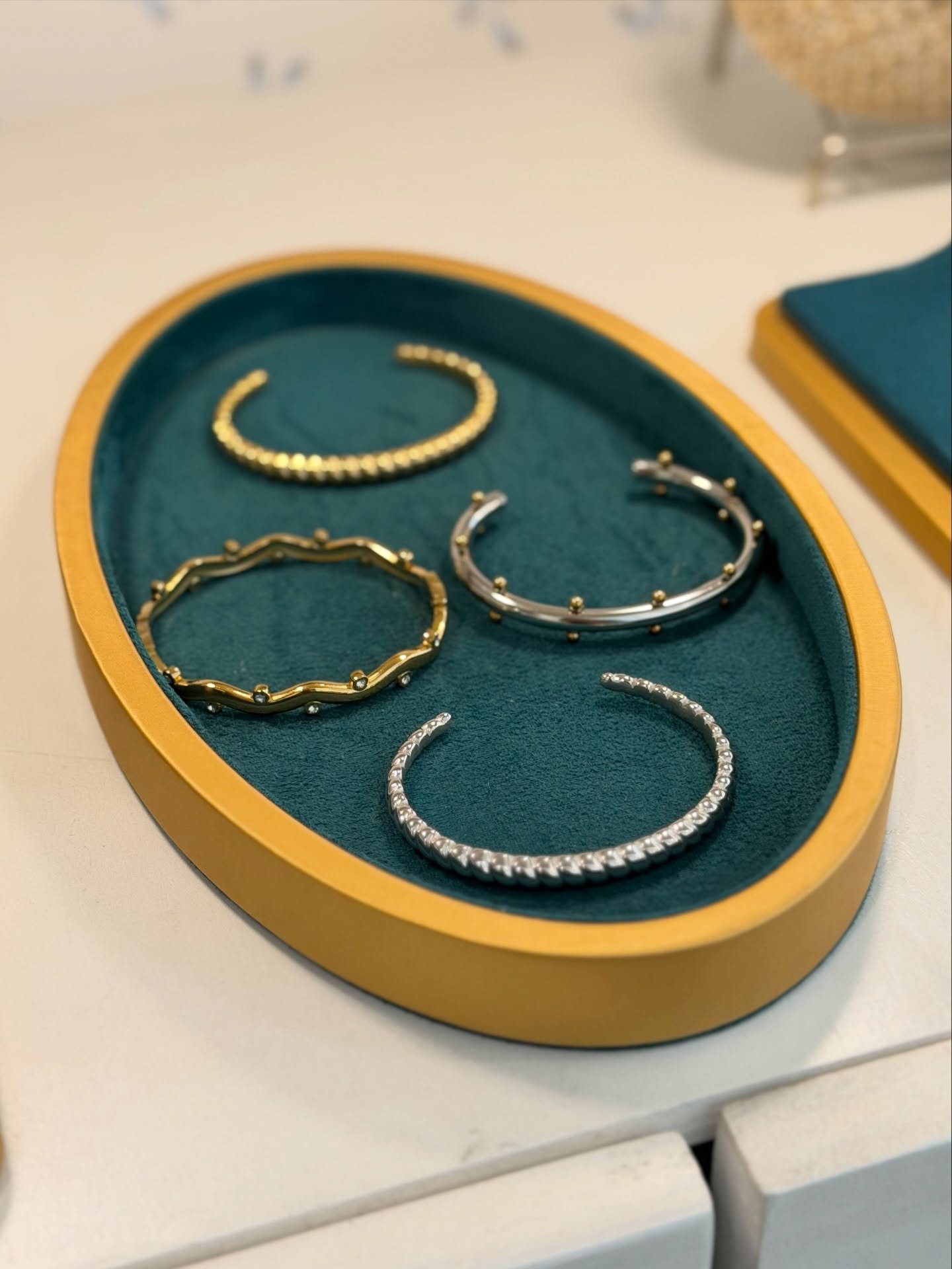 Charola ovalada con cuatro cuffs y brazaletes sobre terciopelo